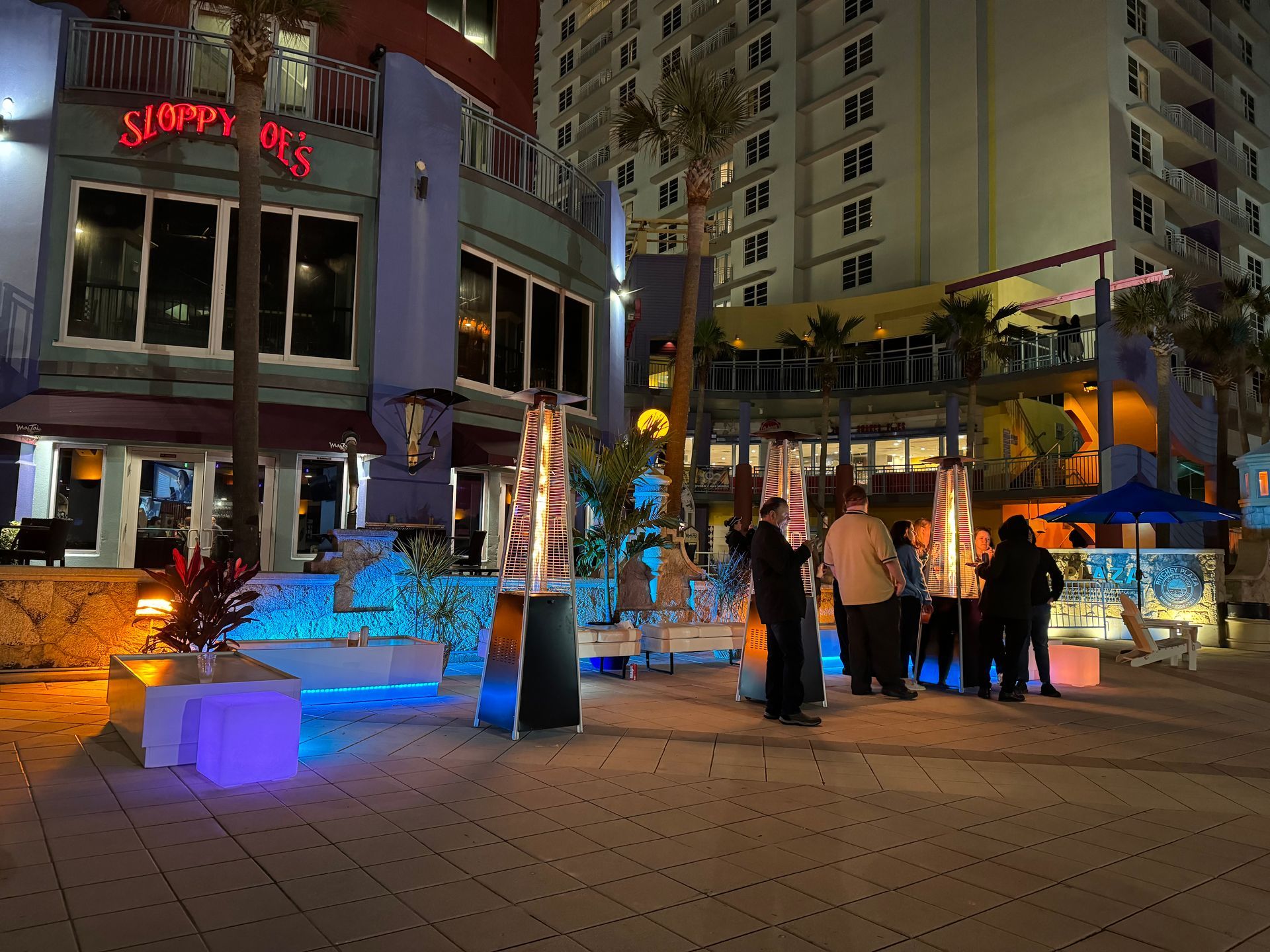 people at a beach themed event enjoying warmth by the fire