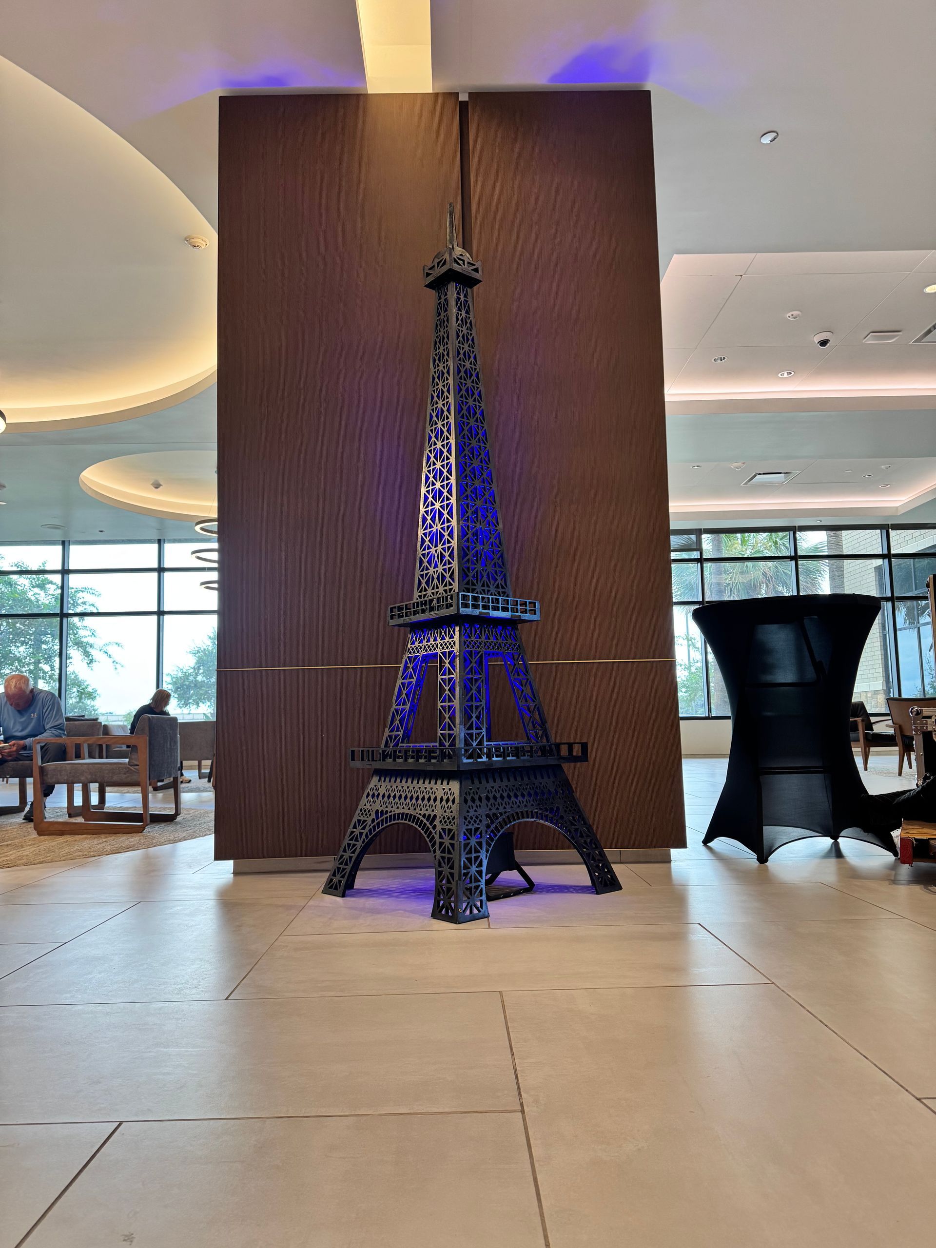 Miniature Eiffel Tower replica with blue lighting in a modern indoor setting.