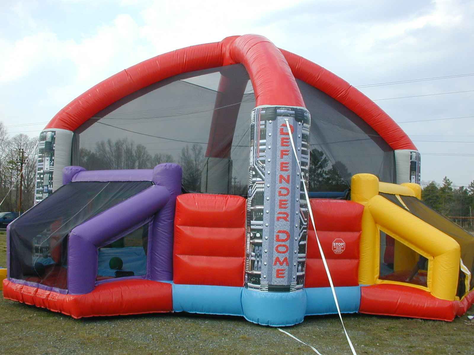  Large inflatable dodgeball arena with bright colors and multiple entry points.