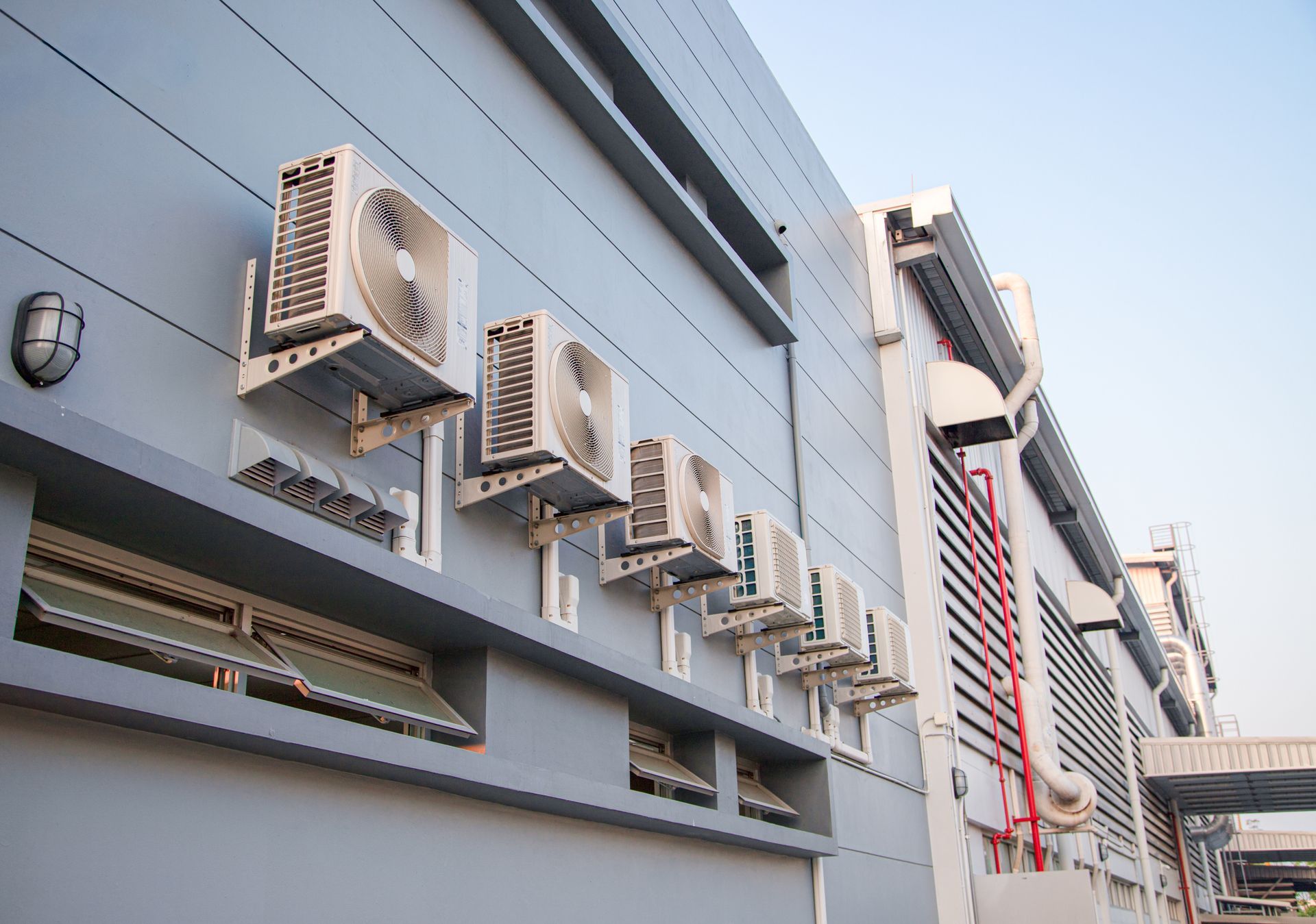 Row of wall-mounted air conditioning units on a building exterior