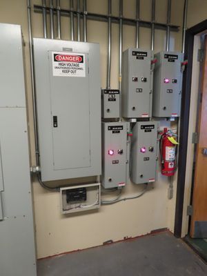 A gray electrical control panel wall with a 