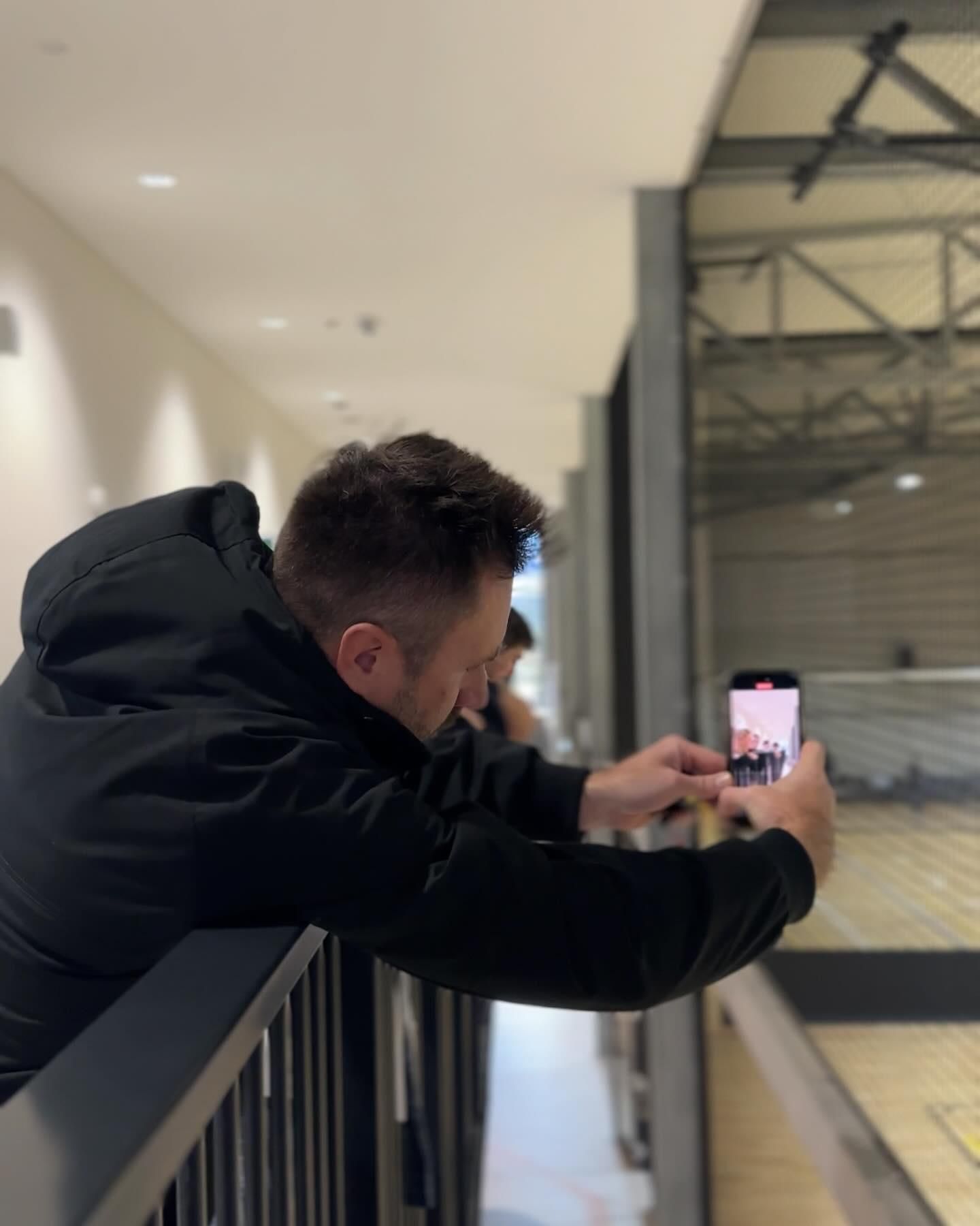 A Man in a Black Jacket is Taking a Picture With His Phone — Gem Socials In South West Rocks, NSW