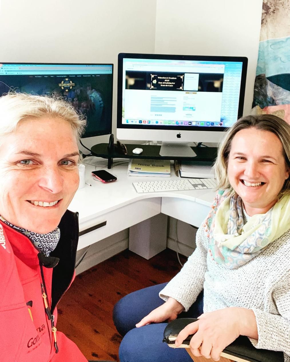 Two Women Are Sitting in Front of a Computer and Smiling — Gem Socials In Port Macquarie, NSW