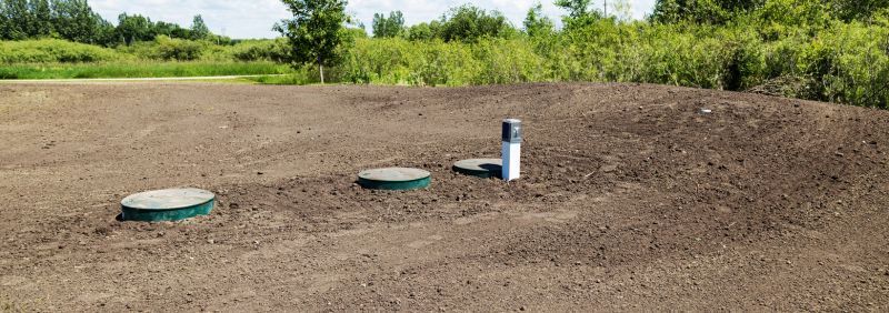 There are two septic tanks in the middle of a field.