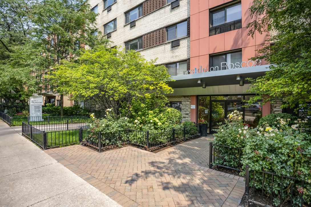 Reside on Roscoe apartment building with a lot of windows and trees in front of it in Lakeview, Chicago.