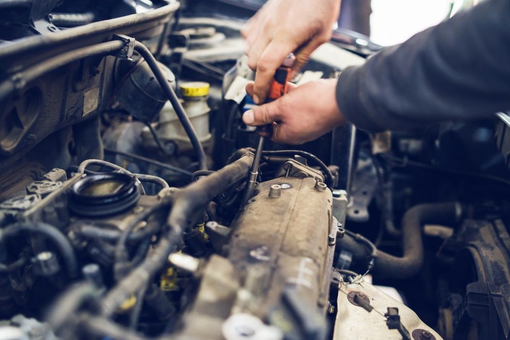 A hand has a clamp while working on car — East Lismore Automotive in  East Lismore, NSW