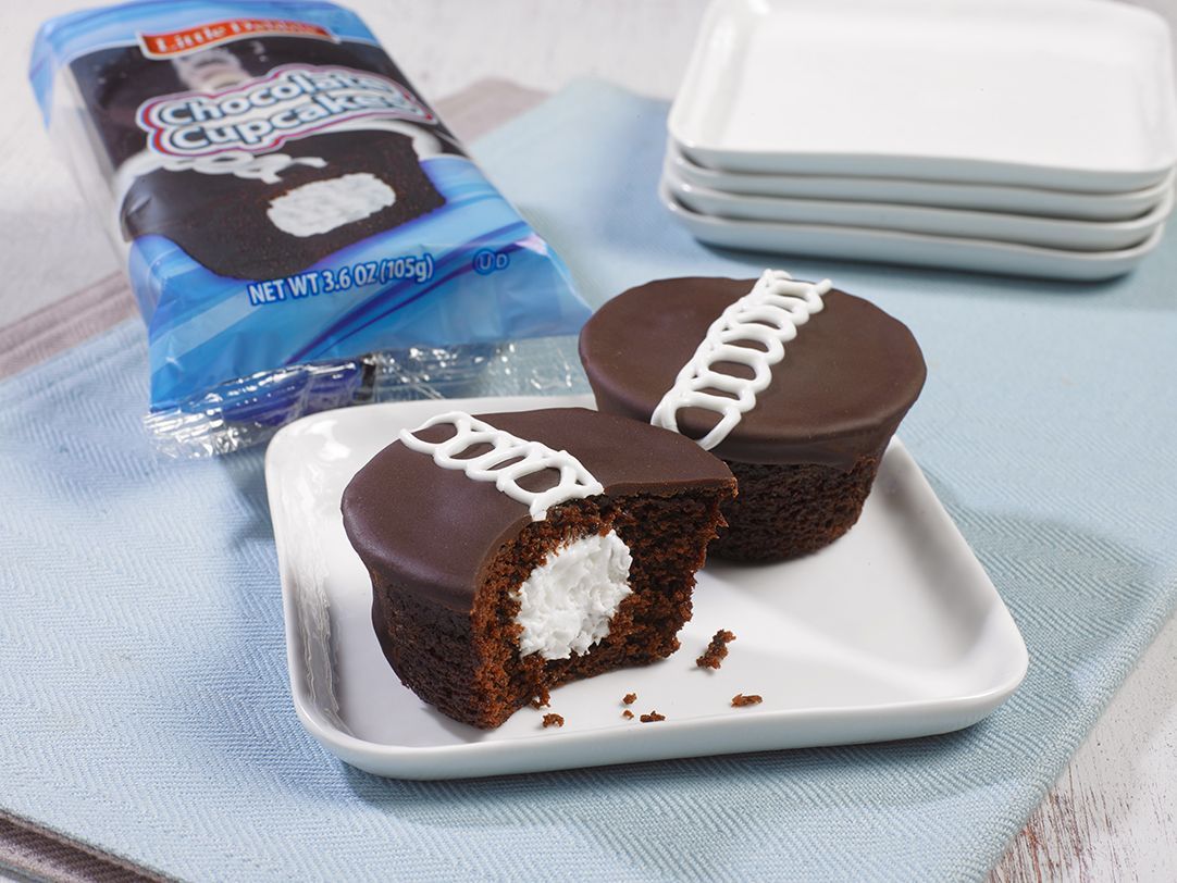two single serve chocolate cupcakes on a plate by a wrap