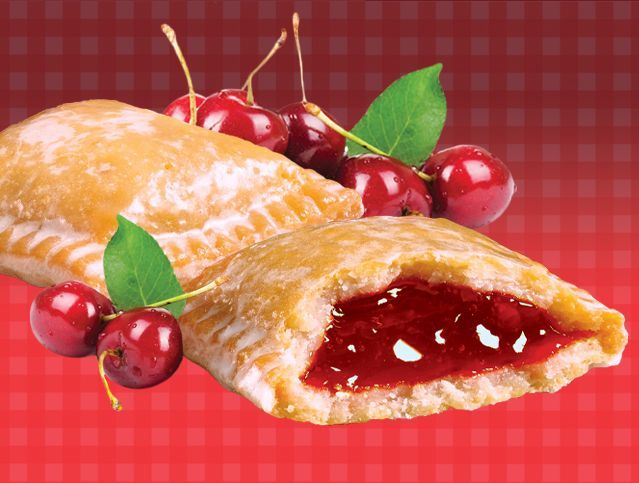 A pastry with cherries on a red checkered table cloth