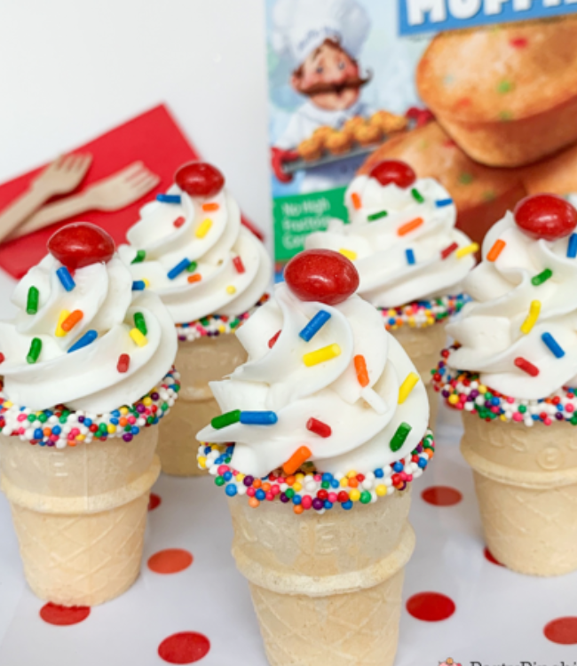 birthday cake mini muffins in ice cream cones and topped with frosting