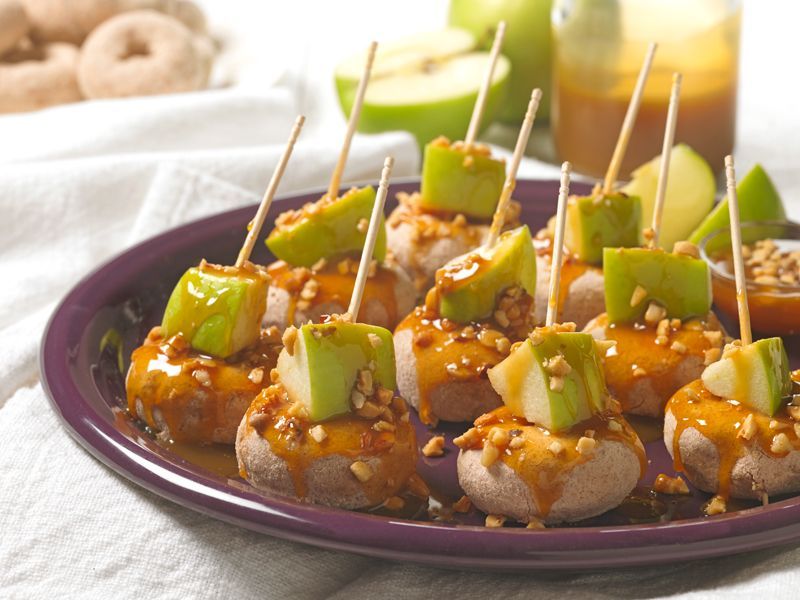 pumpkin spice mini donuts topped with caramel sauce, nuts and green apple slices