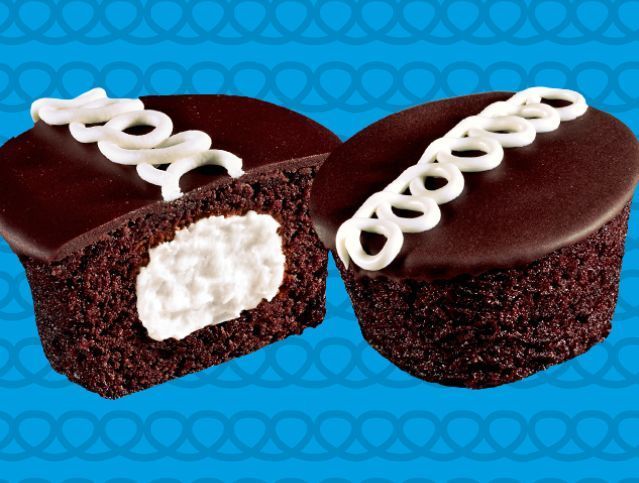Two pieces of chocolate cake with white frosting on a yellow and white striped background