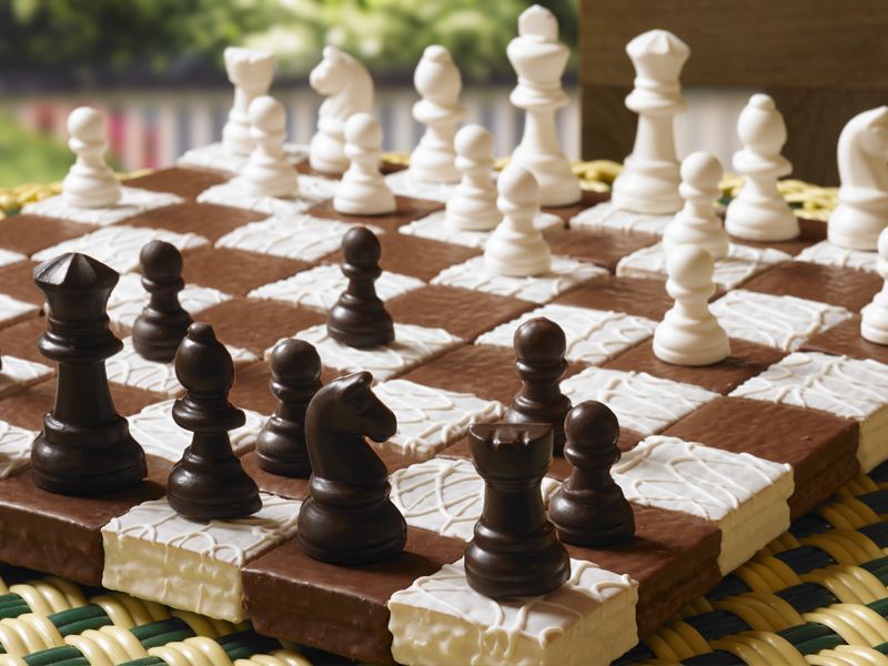 A chocolate chess board with white pieces on it