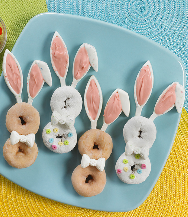 glazed and powdered mini donuts decorated as easter bunnies on a blue plate