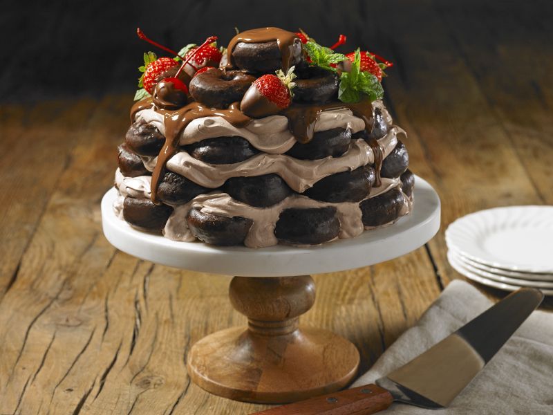 A chocolate cake with strawberries and chocolate sauce on top