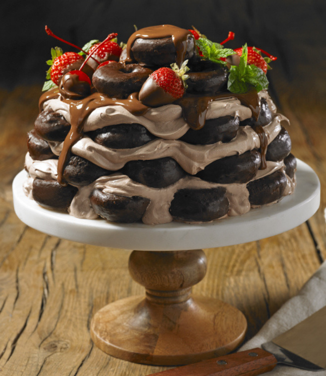 A chocolate cake with strawberries and chocolate sauce on top