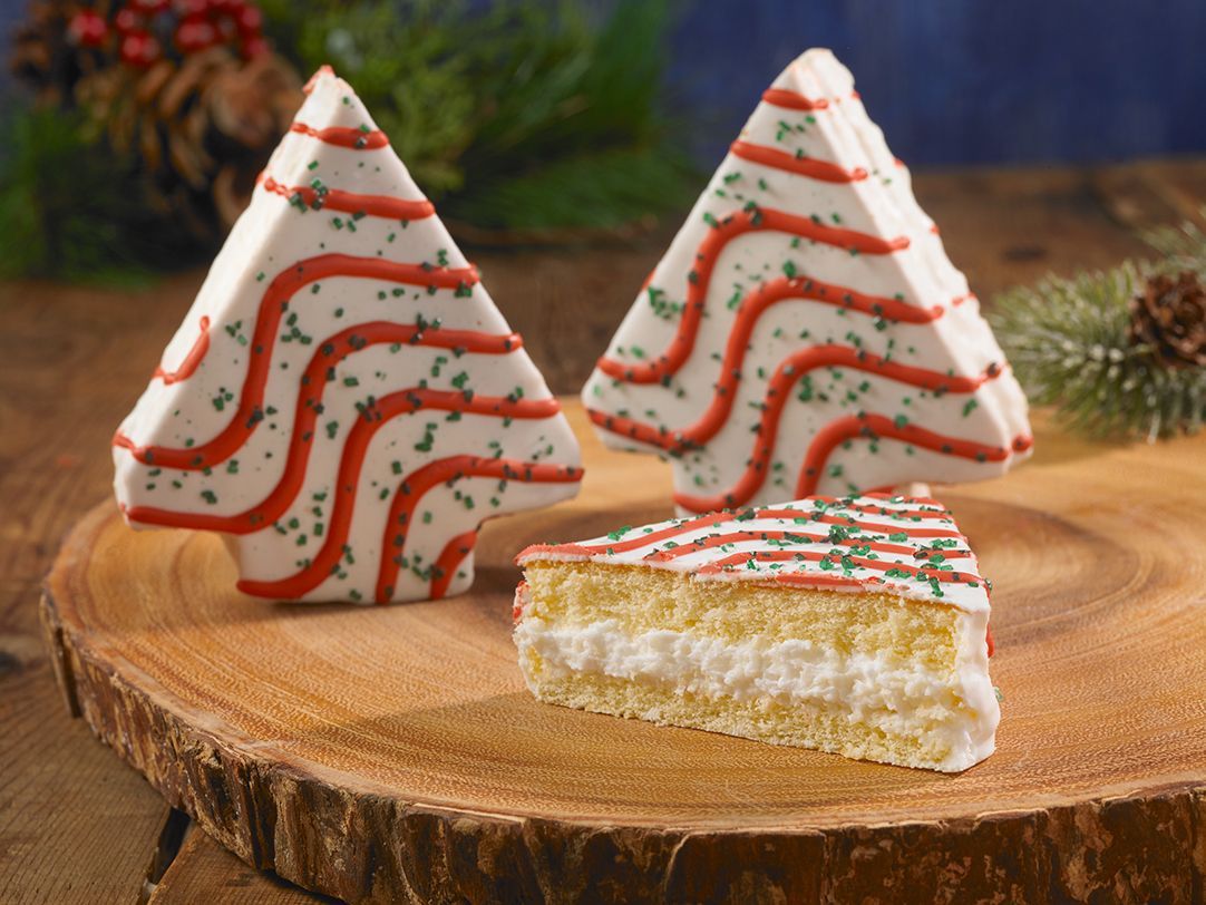 A christmas tree shaped cake next to a slice of cake