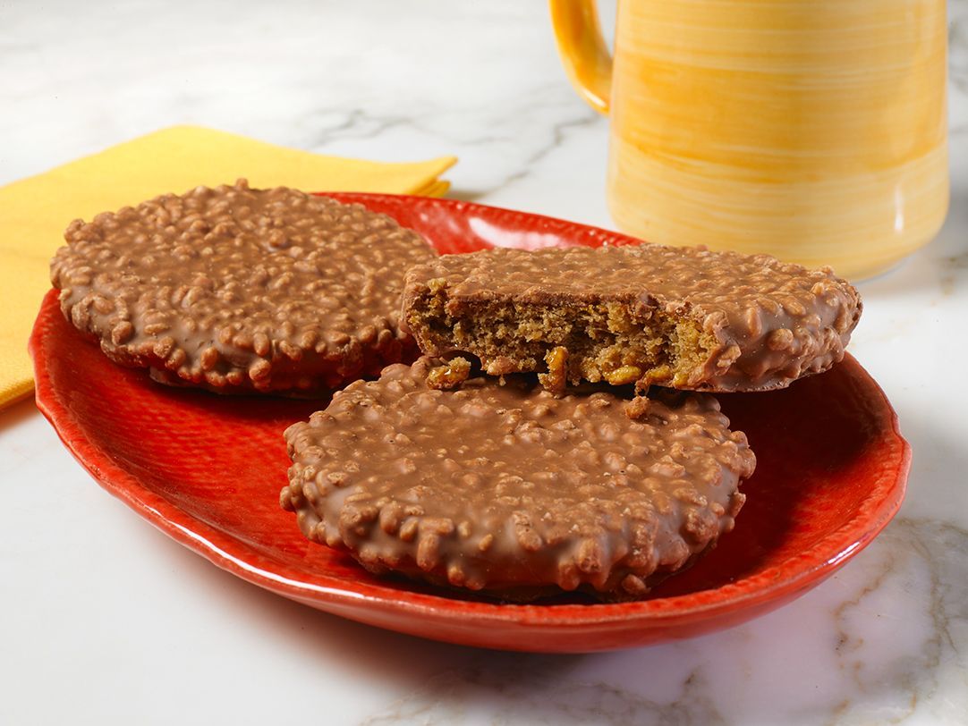 A plate of star crunch cookies next to a box