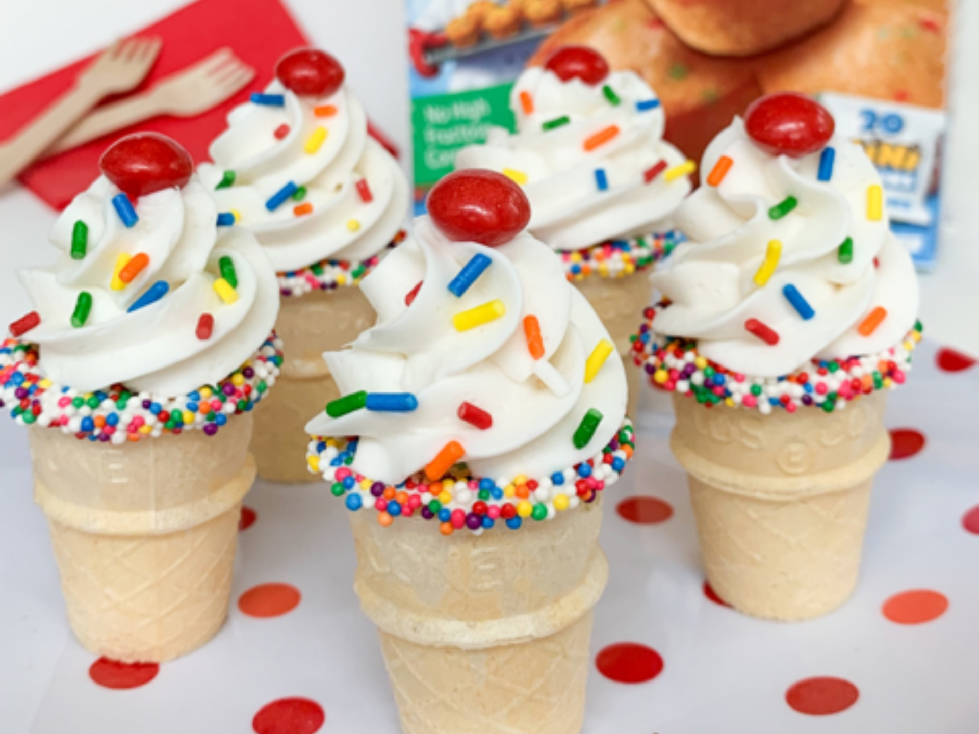 Ice cream cones decorated to look like cupcakes with whipped cream and sprinkles