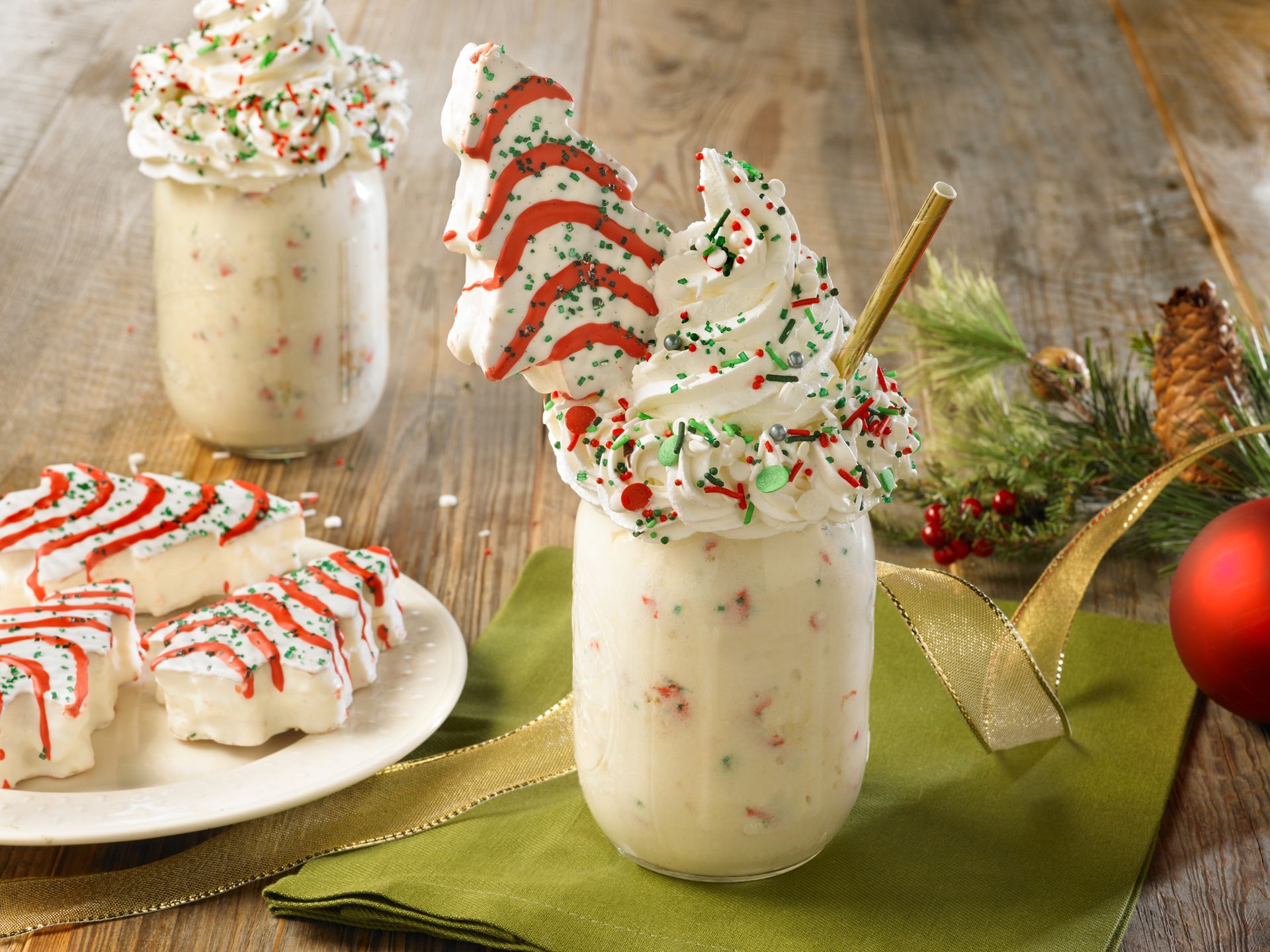 christmas tree cake milkshake topped with whipped creme and sprinkles