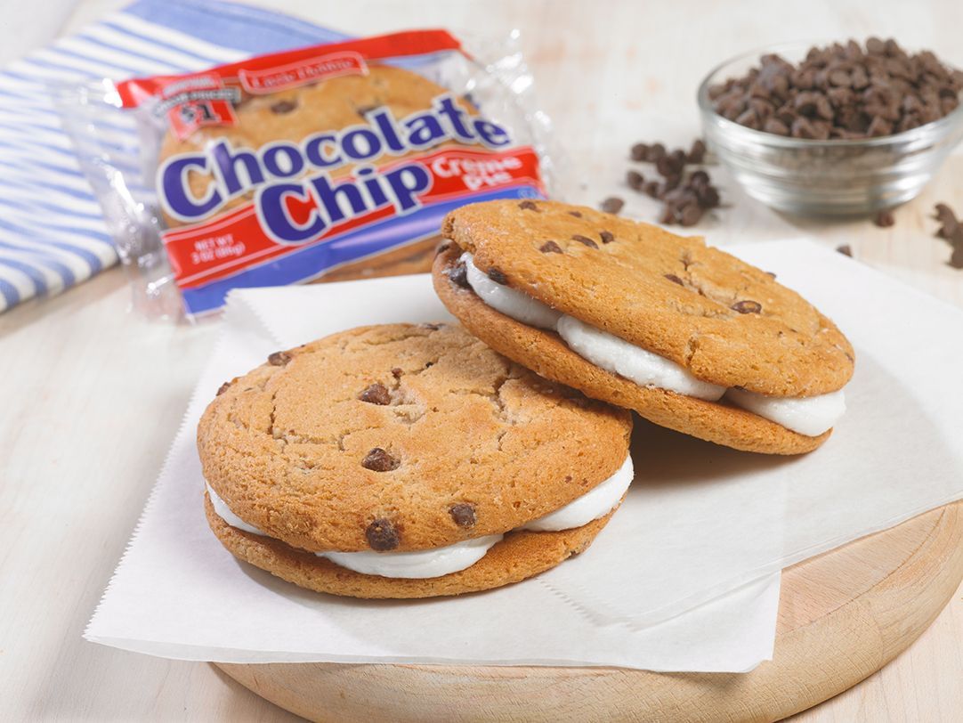 two single serve chocolate chip creme pies on a white plate next to a wrapped one