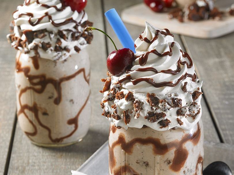 A milkshake with whipped cream and a cherry on top