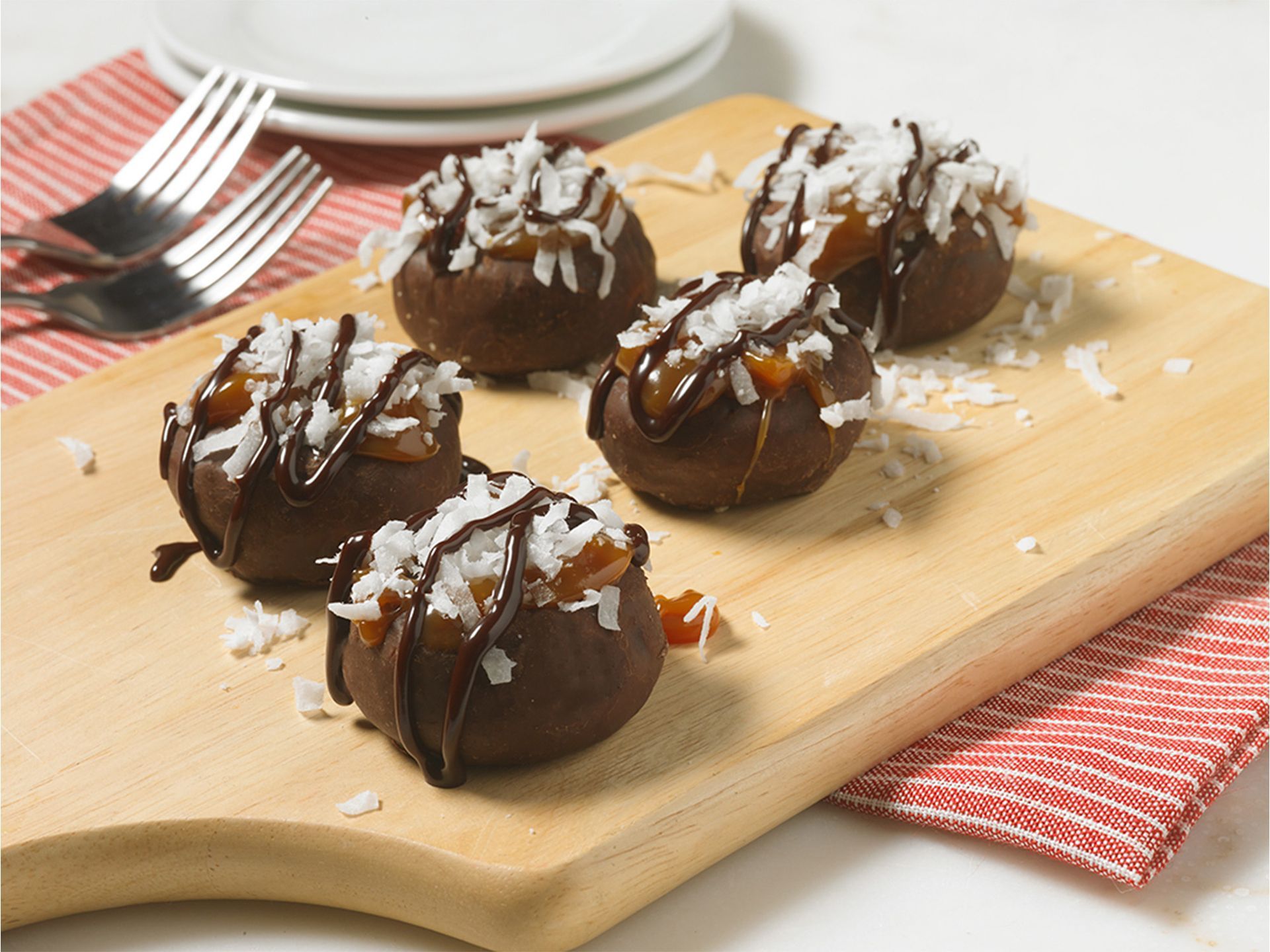 fudge round mini donuts topped with coconut flakes, caramel sauce and chocolate sauce