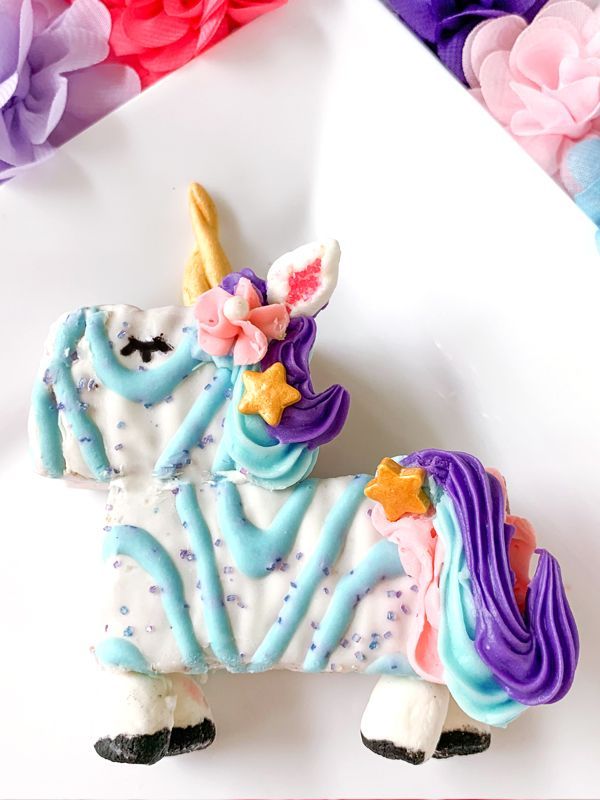 A unicorn cookie with blue frosting and a purple mane