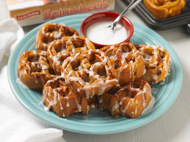 a plate of pecan spinwheels served as waffles and topped with icing on a blue plate