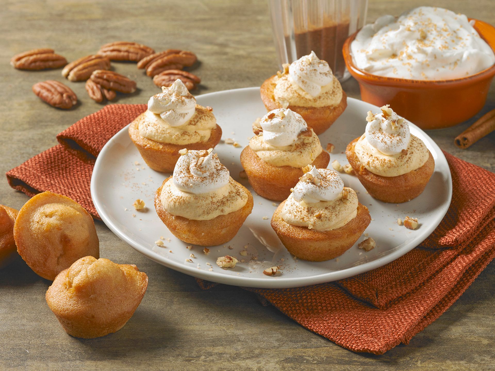 a plate of pumpkin spice mini muffins topped with pumpkin mousse in a fall theme