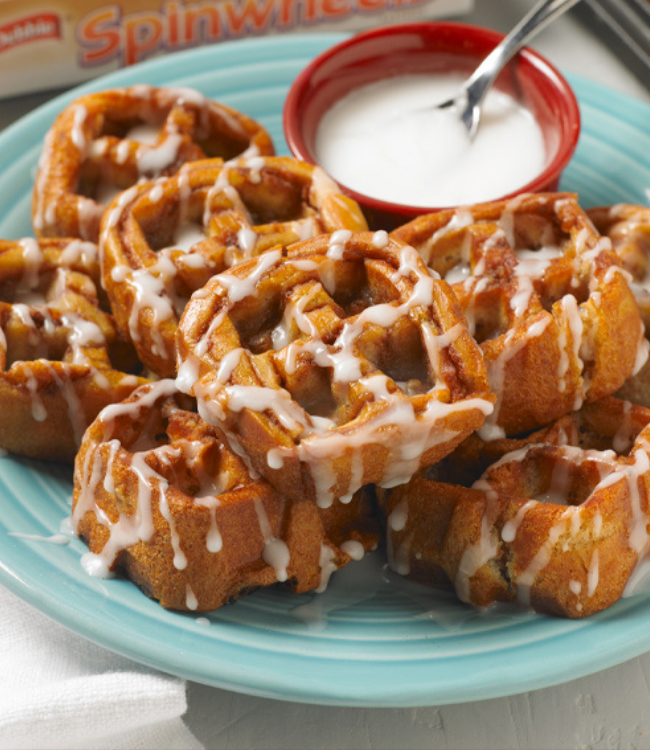 a plate of pecan spinwheels served as waffles and topped with icing on a blue plate