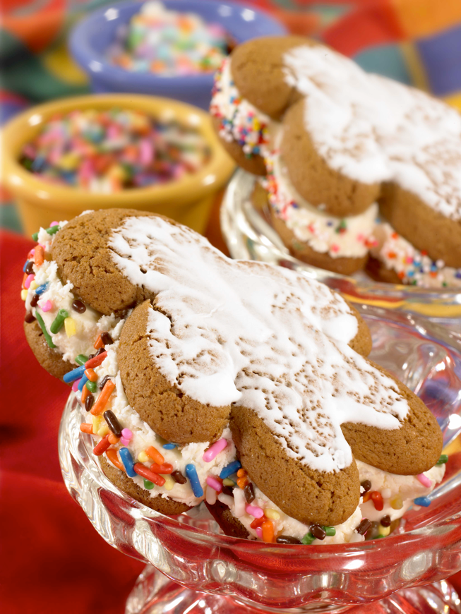 gingerbread cookies sandwiching ice cream and rolled in sprinkles