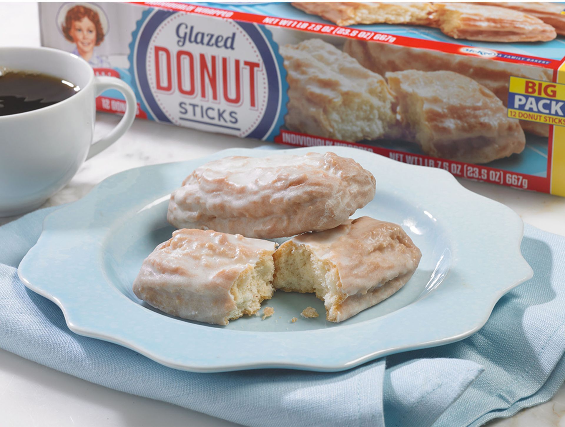 two big pack donut sticks on a blue plate next to a carton