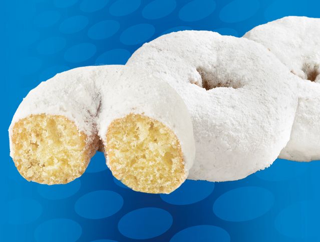 Three powdered sugar donuts on a blue background