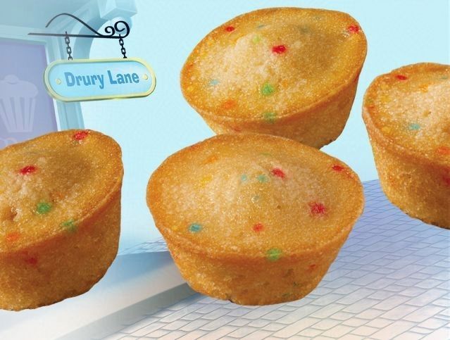 Four cupcakes on a table with a sign that says drury lane