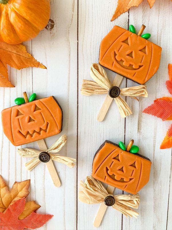 pumpkin brownies on a popsicle stick with festive fall straw on a white background