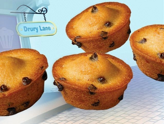 Four muffins on a table with a sign that says drury lane