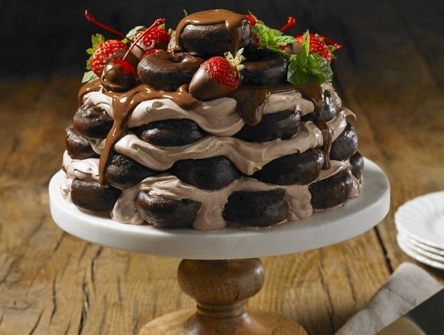 A chocolate cake with strawberries and chocolate sauce on top