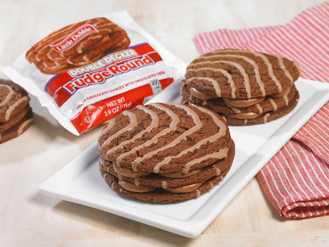 two double decker fudge rounds on a white plate next to a wrapped one
