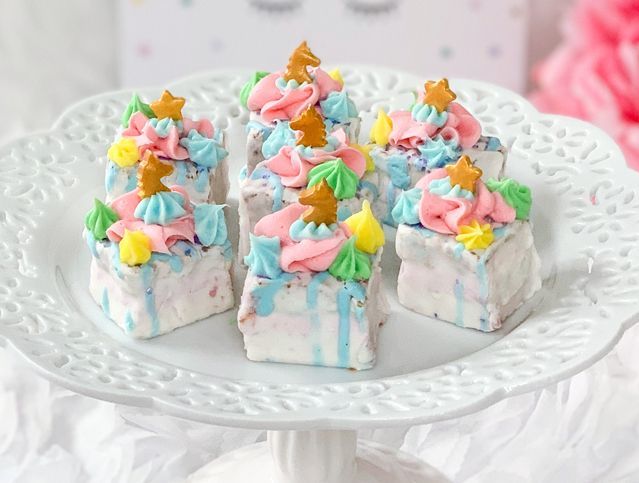 A white plate topped with marshmallows decorated like christmas trees.