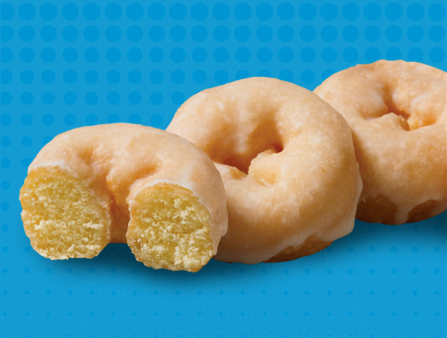 three glazed mini donuts with one missing a bite