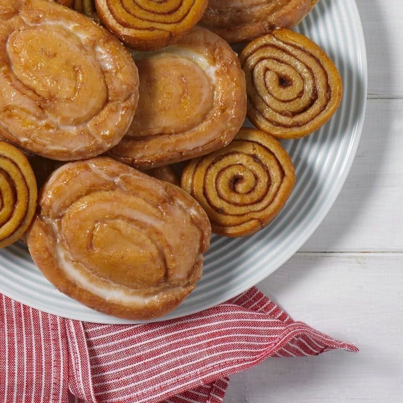 a plate of honey buns and pecan spinwheels on a white plate with a red napkin and a white background