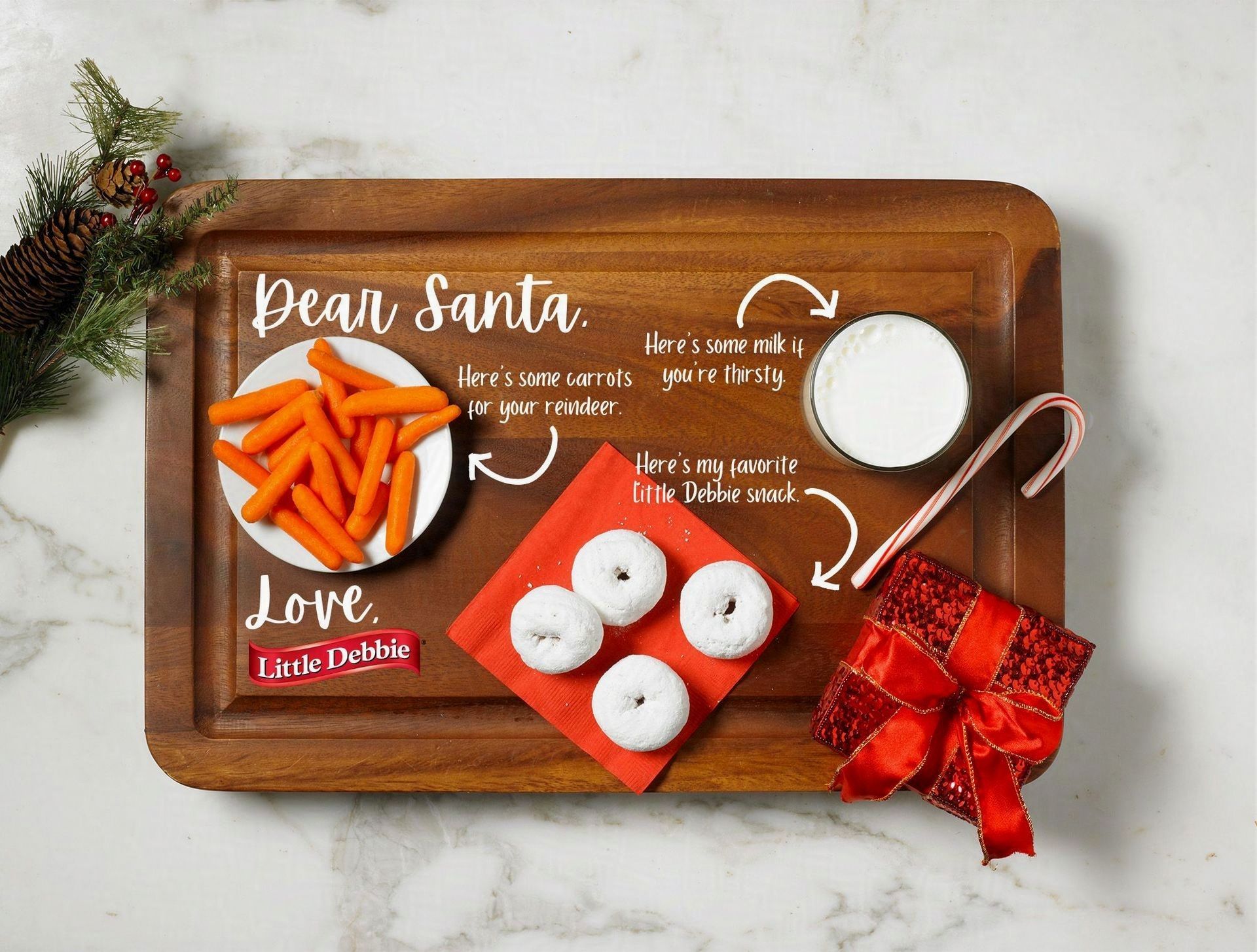 A wooden tray with a plate of carrots and donuts on it.
