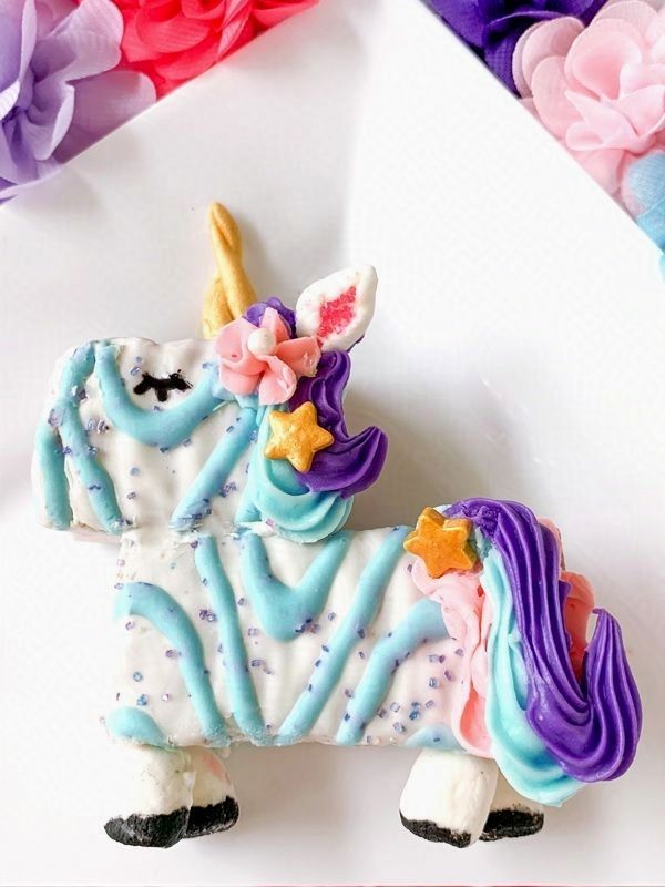 A unicorn cookie with blue frosting and a purple mane