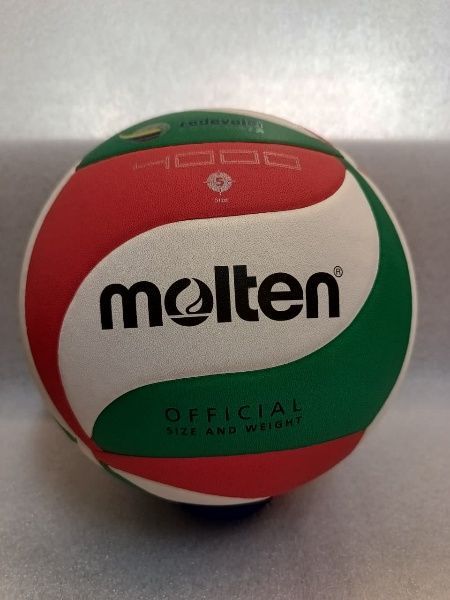 Balón oficial de voleibol Molten rojo, verde y blanco sobre un fondo gris.