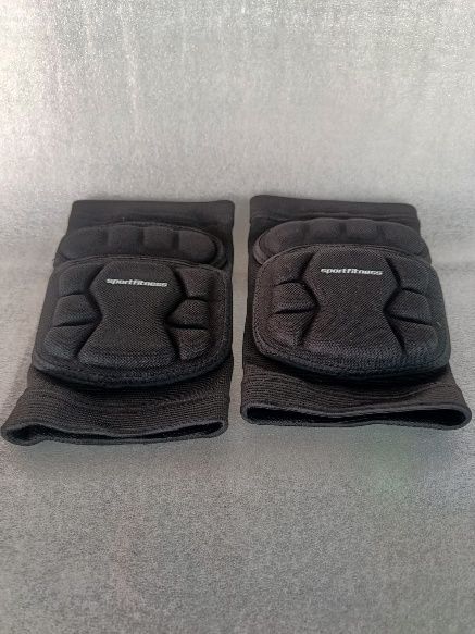 Un par de guantes acolchados negros colocados uno al lado del otro sobre una superficie gris.