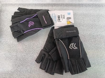 Dos pares de guantes negros sin dedos con detalles morados y grises sobre una superficie gris.