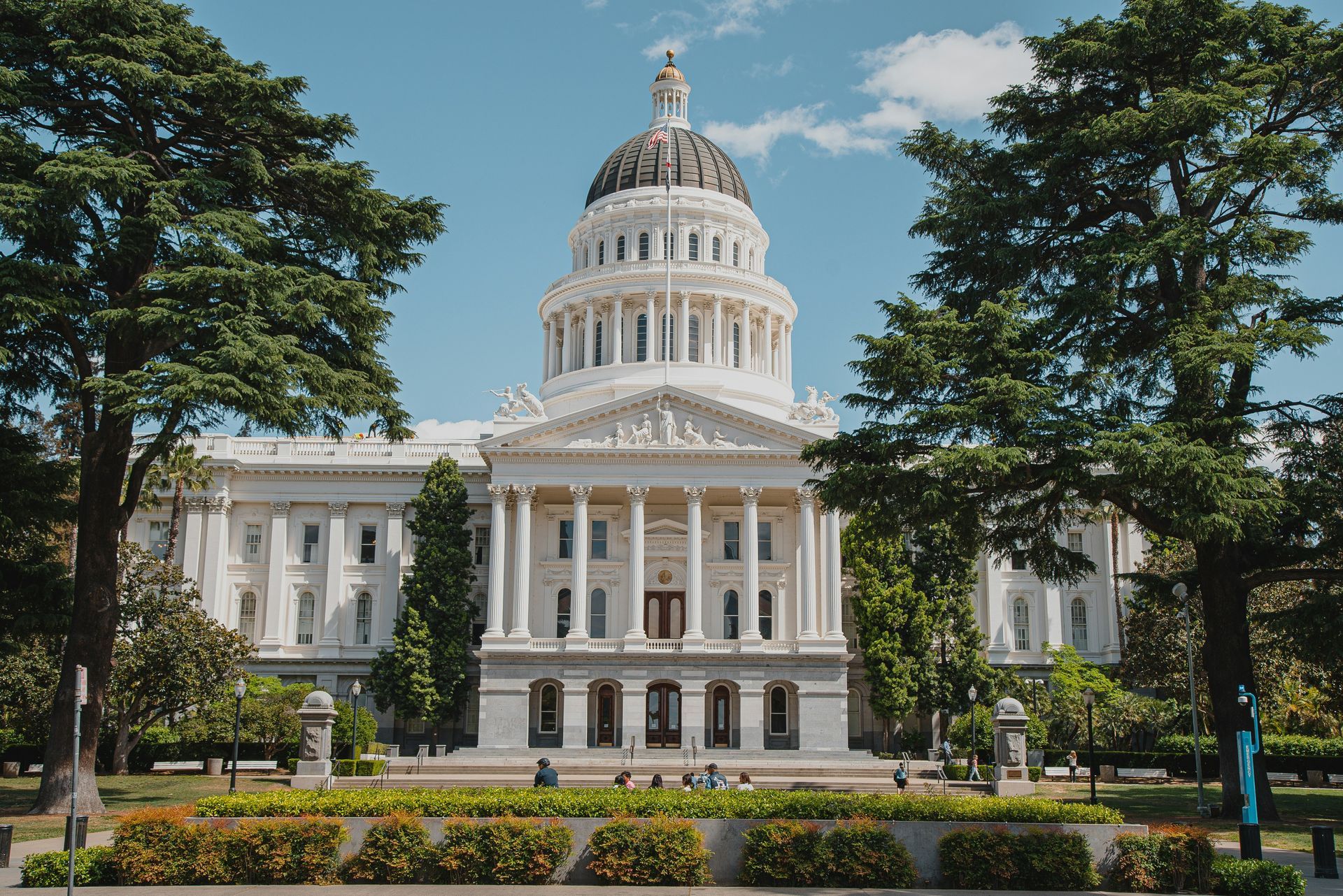 California State Capitol Building framed by trees, sunny day.