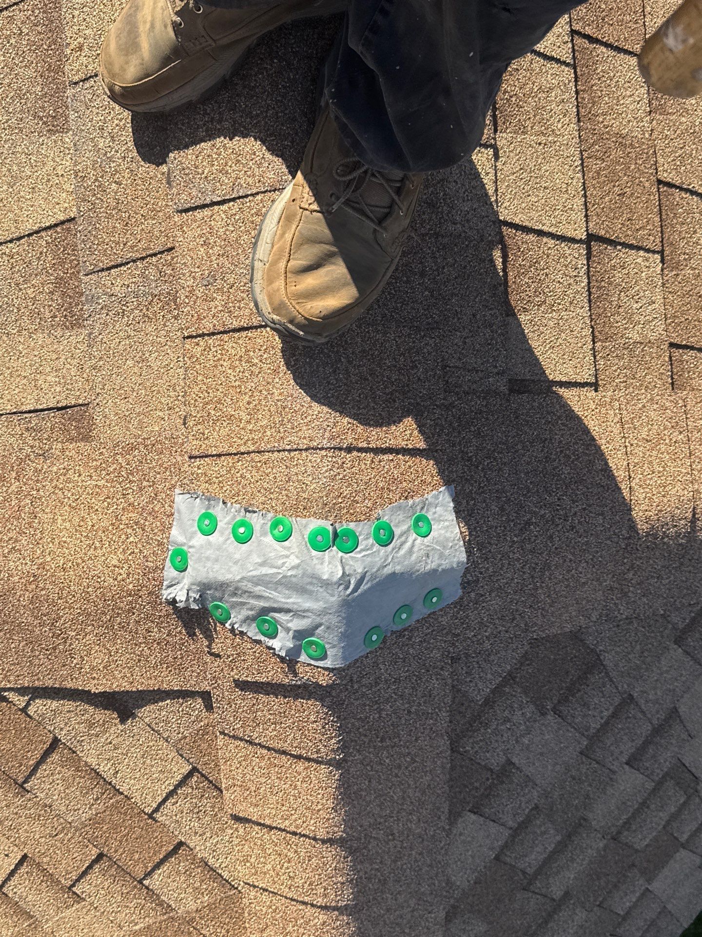 A person is standing on a roof with a piece of duct tape on it.