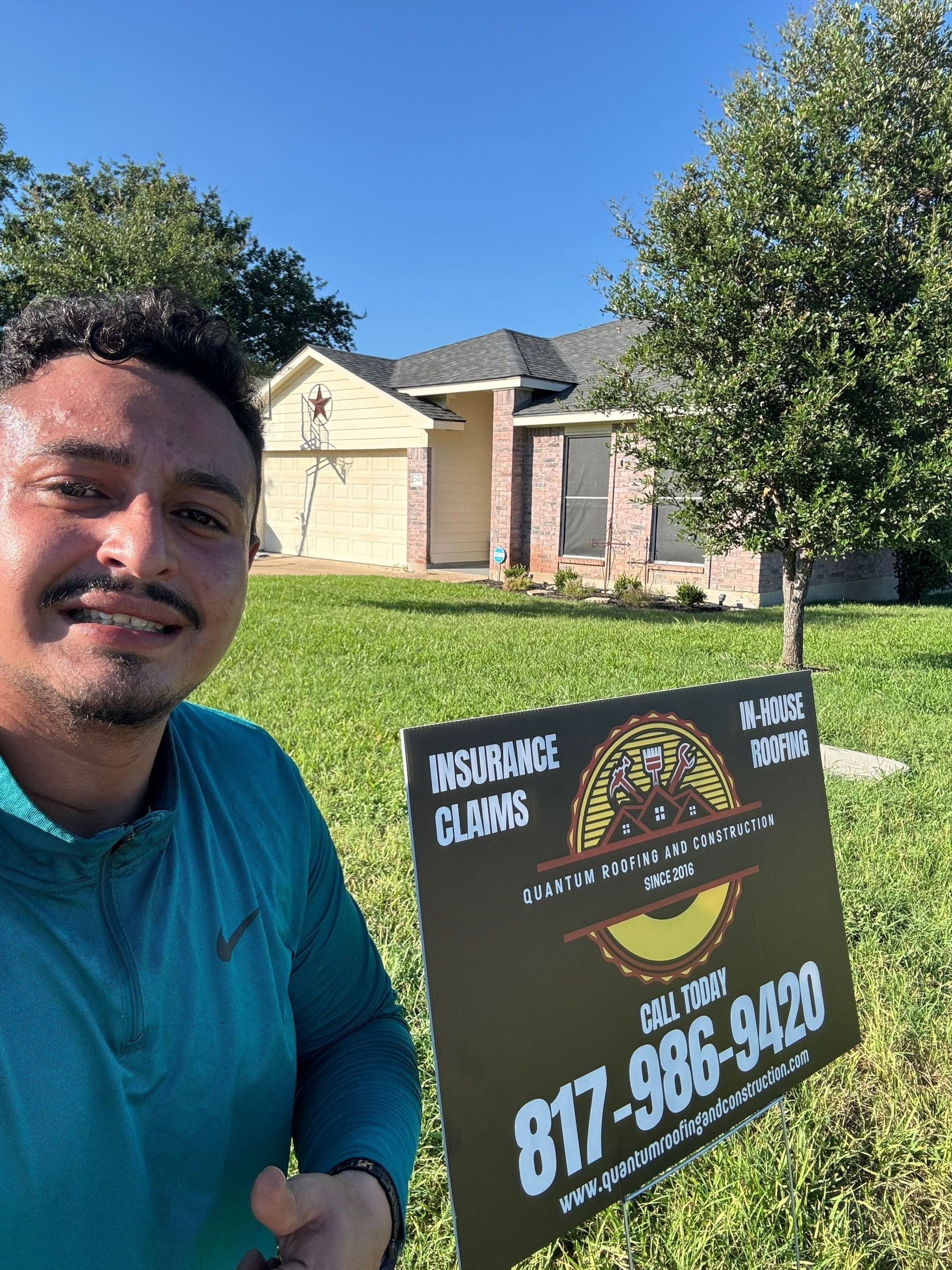 A man is holding a sign in front of a house.