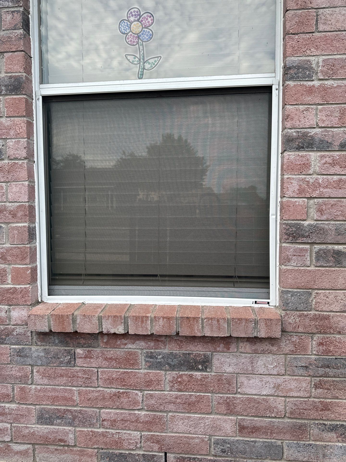 A brick building with a window with a flower on it